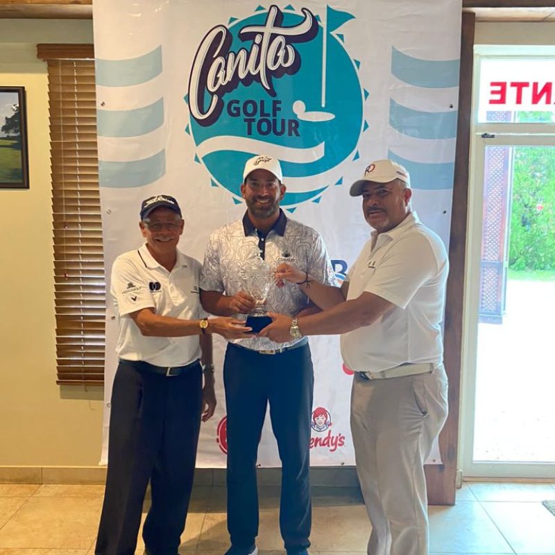Hiram Silfa (centro), recibe el trofeo de campeón por parte de Rafael Canario y Luis Jose Placeres, de Fedogolf
