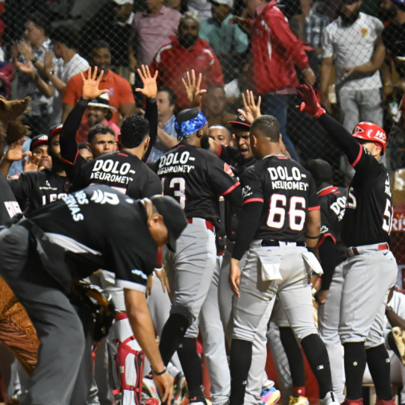 Jugadores del Escogido celebran luego de anotar dos carreras en el octavo inning.