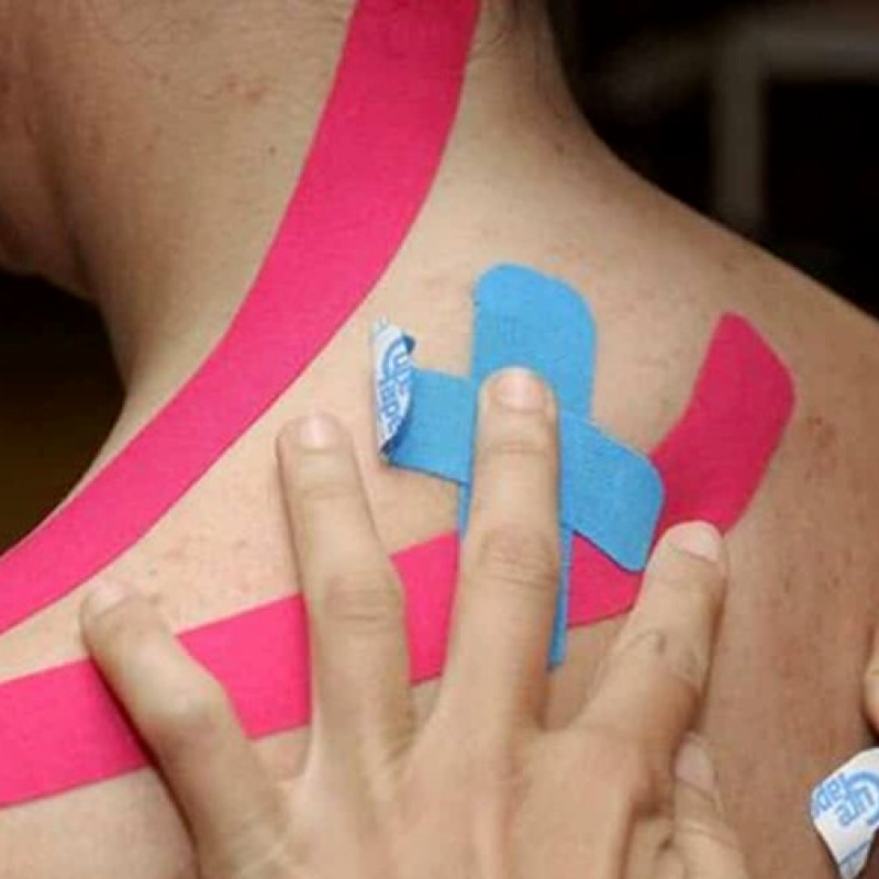 Una fisioterapeuta aplica cintas kinesiológicas, utilizadas por los atletas para aliviar el dolor